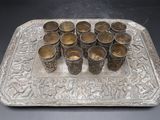 a silver tray with cups on it on a table