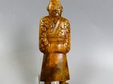 une vieille figurine sculptée représentant un homme portant un chapeau et un manteau