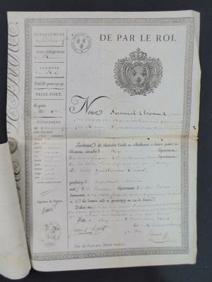 an old document sitting on top of a table next to a roll of paper