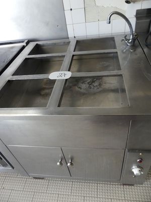 un évier en acier inoxydable dans une cuisine équipée d'un plan de travail en métal