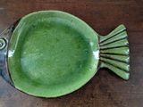 a green plate with a fish design on it