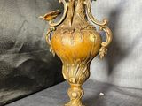 a gold vase on a table with a black background
