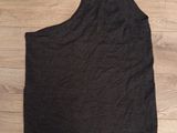 a black tank top on a wooden floor next to a pair of shoes