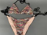 an image of a woman ' s bikini top and panties on a gray surface