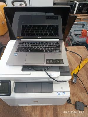 a laptop computer sitting on top of a printer on a table