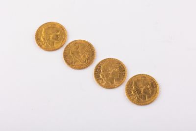 four gold coins are arranged in a row on a white surface