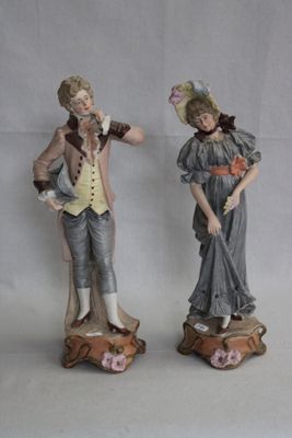 deux figurines d'un homme et d'une femme debout l'un à côté de l'autre