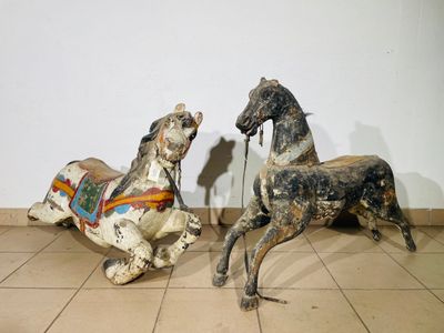 two wooden horses that are sitting on a tile floor