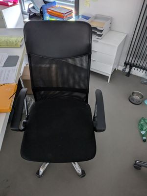 a black office chair sitting in the corner of a room