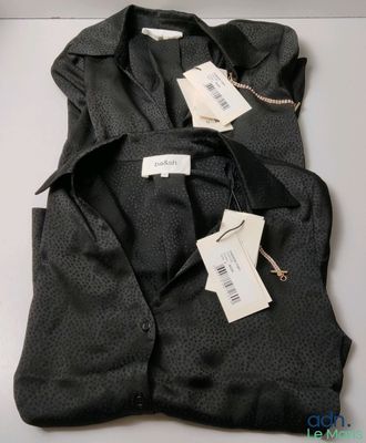 deux t-shirts noirs, encore étiquetés, posés sur une table