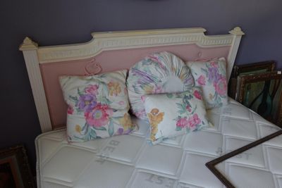 un lit blanc avec une tête de lit rose et des oreillers posés dessus
