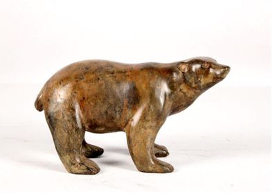 une petite statue représentant un ours polaire sur fond blanc