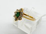 an image of a gold ring with a green stone surrounded by white diamonds