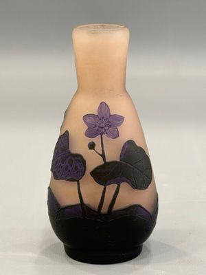 un vase orné d'une fleur violette sur un fond blanc