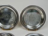 three silver plated dishes with gold rims on a white surface