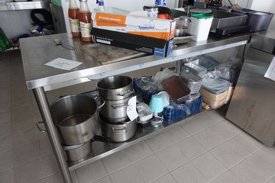 un plan de travail en acier inoxydable sur lequel sont posés des casseroles et des poêles