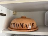 a brown bowl on top of a shelf in a kitchen