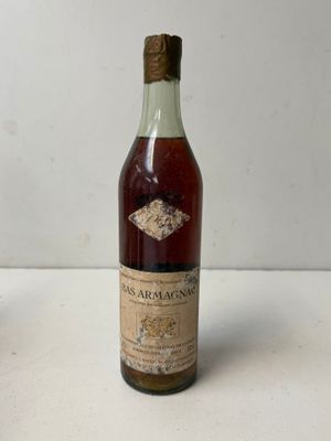 an old bottle of wine sitting on top of a white table