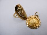 a close up of a gold locke and a ring on a white surface