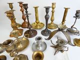 many different types of brass candlesticks on the table
