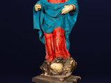 une vieille statue représentant une femme vêtue d'une robe bleue et d'une jupe rouge