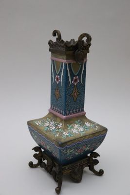 un vase posé sur un support sur une surface blanche