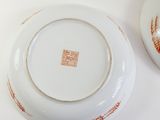two plates that have orange designs on them