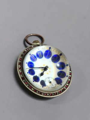 un gros plan d'une montre de poche ornée de fleurs bleues et blanches