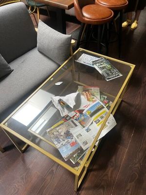 une table basse en verre sur laquelle sont posés des magazines, dans un salon