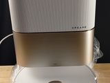 une enceinte blanche et dorée posée sur une table en bois