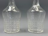 pair of clear glass vases on a gray surface