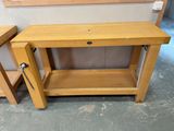 a wooden table with a shelf on it and a small table with a drawer underneath it