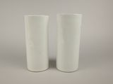 pair of white ceramic vases on a grey background