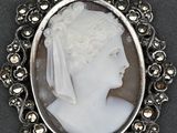 an image of a woman ' s profile in a silver broocher