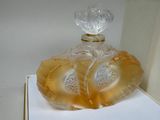 a yellow glass perfume bottle sitting on top of a white box