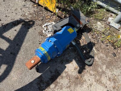 a blue machine that is laying on the ground next to a fence