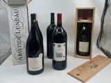 Plusieurs bouteilles de vin sont alignées sur une table à côté d'un sac