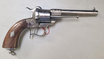 un gros plan d'un revolver posé sur une table, avec un cordon rouge