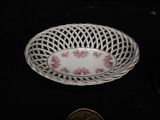a white bowl with pink flowers on it on a black surface