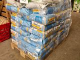 many bags of rice sitting on a pallet in a warehouse