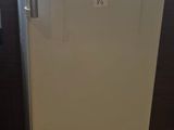 a white refrigerator sitting in a kitchen next to a window