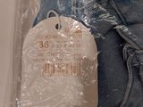 a tag on a pair of blue jeans in a plastic bag