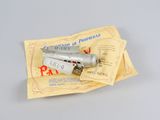 un petit avion argenté posé sur une feuille de papier