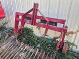 un tas de vieilleries devant un immeuble entouré d'une clôture rouge