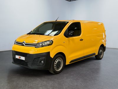 La camionnette jaune est garée dans une grande pièce blanche.