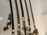 cinq types d'armes différents exposés dans une vitrine