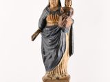 an old statue of a woman holding a child on a pedestal