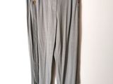 un pantalon gris suspendu à un cintre devant un mur blanc