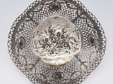 an antique silver plate with a picture of a man and a woman in a boat