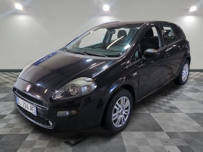 the small black car is parked on a checkered tile floor